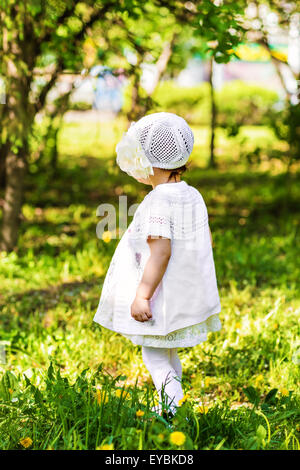 little girl standing in the grass Stock Photo