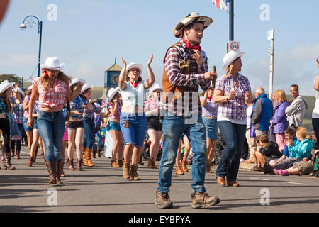 Swanage, Dorset UK 26 July 2015. Swanage Carnival Procession in July with the theme of Superheroes - cowgirl line dancer  Credit:  Carolyn Jenkins/Alamy Live News Stock Photo