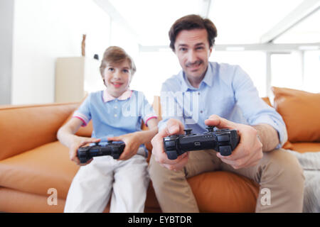 father and son play video game Stock Photo