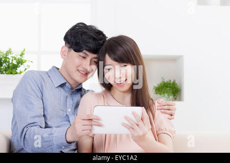 Pregnant woman holding digital tablet and looking with husband, Stock Photo