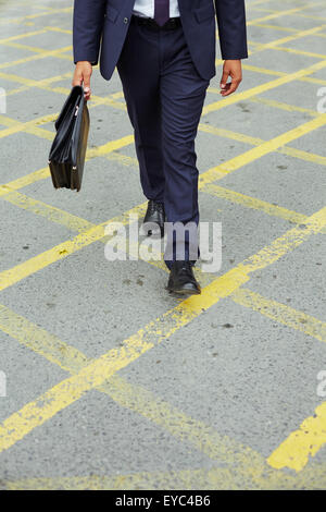 Businessman in suit walking down trottoire Stock Photo