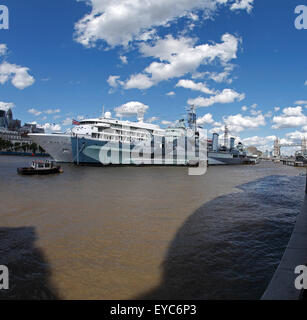 HMS Belfast on the River Thames, London UK. Moored alongside a Cruise ship. Stock Photo