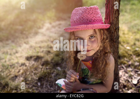 Smiling girl in a hat with dandelions Stock Photo