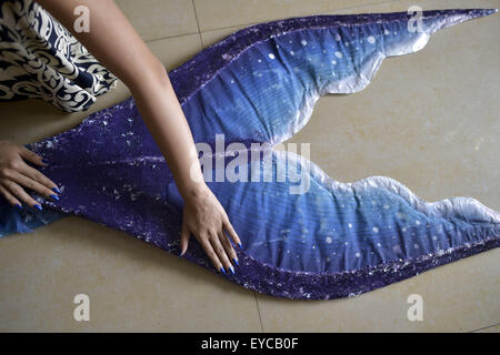 July 26, 2015 - Chongqing, Chongqing, CHN - CHONGQING, CHINA - July 26 2015: (EDITORIAL USE ONLY. CHINA OUT) Pan is weaving mermaid costumes. The fairy tale ''The Little Mermaid'' tells a story of pursuing true love at the cost of turning into foams. Does mermaid only exist in fairy tale?Not always. There's a girl in Chongqing who waving her mermaid dream herself. Pan Gaojie, a professional model who attended the car exhibition before, with a height of 1.7m (5.57 feet) and pretty face, has liked mermaid stories since her childhood. Last summer she performed in mermaid costumes to help in a cam Stock Photo