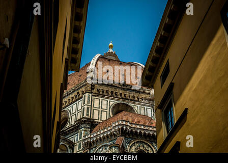 Filippo Brunelleschi's dome on Florence Cathedral glimpsed between buildings in the city of Florence, Italy. Stock Photo