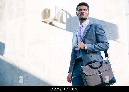 Portrait of a confident businessman standing outdoors near office building Stock Photo