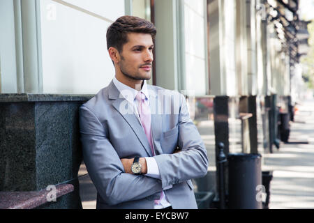 Portrait of a pensive businessman with arms folded standing outdoors in the city Stock Photo