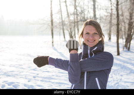 Young woman stretching in snow Stock Photo