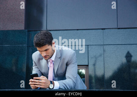 Confident businessman using smartphone outdoors Stock Photo
