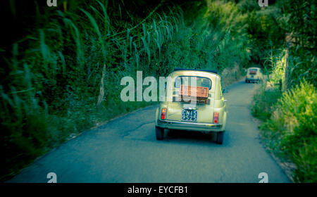 Classic Fiat 500 cars driving on a road in Florence, Italy. Shot from behind. Stock Photo