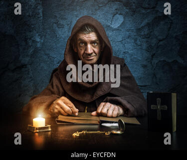 Monk - priest by candlelight - Bible reading Stock Photo