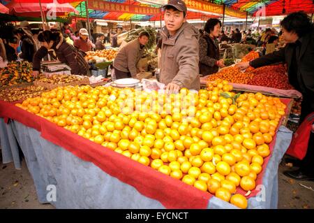 An orange vendor at an open air market in Beijing, China. Stock Photo