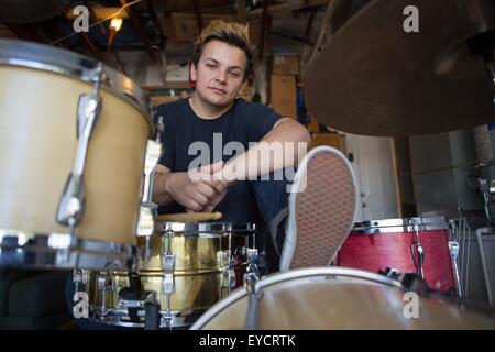 Portrait of young male drummer in basement Stock Photo