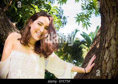 Portrait of teenage girl climbing tree