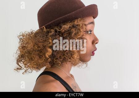 Studio profile portrait of young woman wearing felt hat Stock Photo