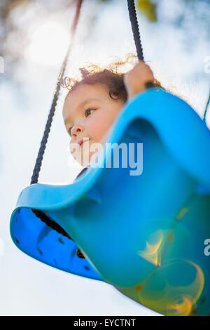 Young girl on playground swing, low angle view Stock Photo