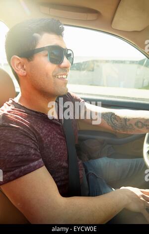 Smiling young man driving car Stock Photo