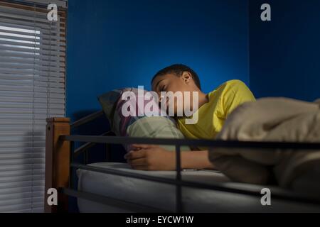 Teenage boy asleep in bunkbed Stock Photo