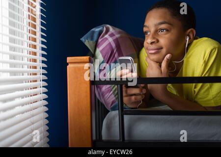 Teenage boy lying in bunkbed looking out of window Stock Photo