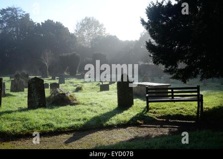 Graveyard in early morning autumn mist with heavy dew on the grass in November Stock Photo
