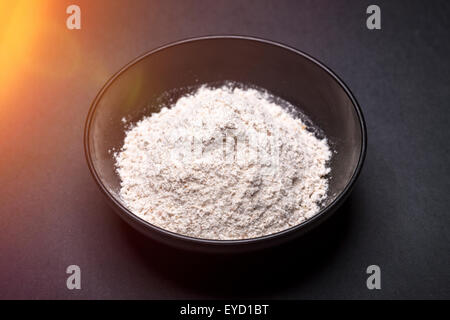 black asian bowl with flour on black background Stock Photo