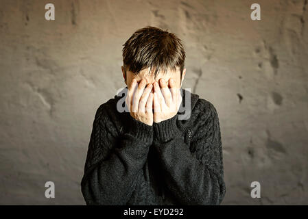 Scared and worried woman covering her face with hands. Selective focus Stock Photo