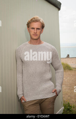 rugged handsome man wearing a tight fitting jumper outdoors Stock Photo