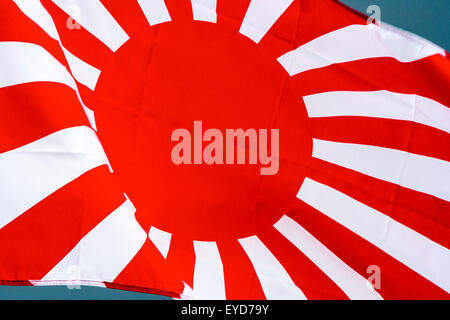 Japanese rising sun flag, Kyokujitsu-ki, Nisshōki or Hinomaru, used by the military in Second world war, dark storm clouds gathering in background. Stock Photo