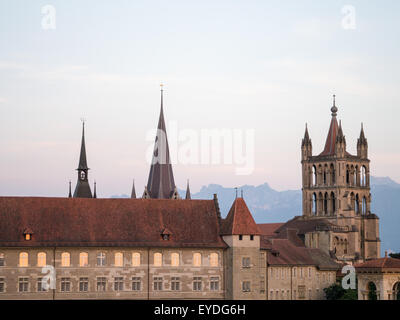 Lausanne cathedral in the evening light with mountains in the background Stock Photo