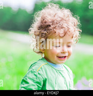 Portrait of 1 year old baby boy having fun on a mountain meadow.