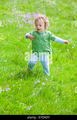 Portrait of 1 year old baby boy having fun on a mountain meadow. Stock Photo