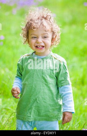 Portrait of 1 year old baby boy having fun on a mountain meadow.