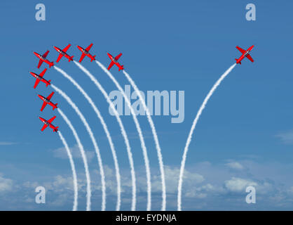 Independent innovation and new thinking concept or leadership symbol of individuality as a group of flying jet airplanes with one individual airplane going in the opposite direction as a business icon for innovative thinker. Stock Photo