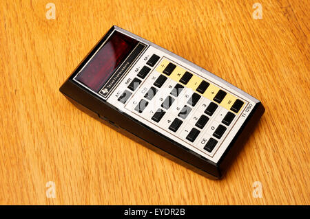 Vintage Texas Instruments TI-1250 basic electronic math calculator introduced in 1975 on an old wooden desk Stock Photo