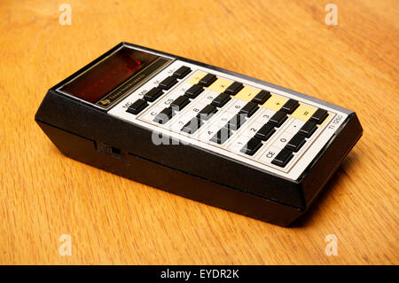 Vintage Texas Instruments TI-1250 basic electronic math calculator introduced in 1975 on an old wooden desk Stock Photo
