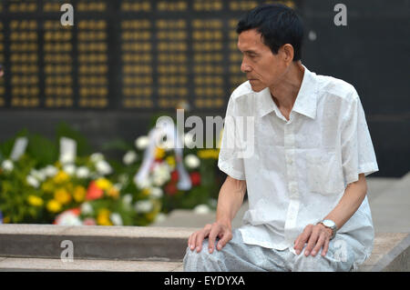 Tangshan, China's Hebei Province. 28th July, 2015. A man mourns for relatives dead in the 1976 Tangshan earthquake in front of the memorial wall in Tangshan, north China's Hebei Province, July 28, 2015. Local residents came to the memorial park on Tuesday to commemorate the 39th anniversary of the Tangshan earthquake. Credit:  Zheng Yong/Xinhua/Alamy Live News Stock Photo