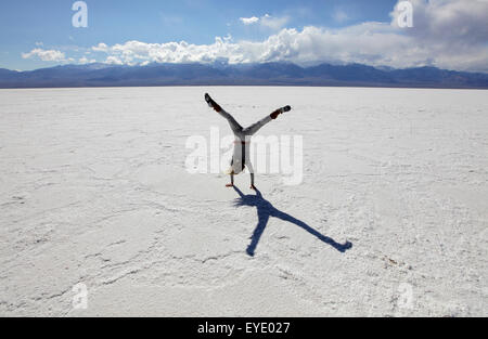 Usa, California, Young Woman Doing Cartwheel On Badwater Salt Flats; Death Valley National Park Stock Photo