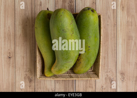 Mangoes from Thailand put in a basket on wood background. Stock Photo