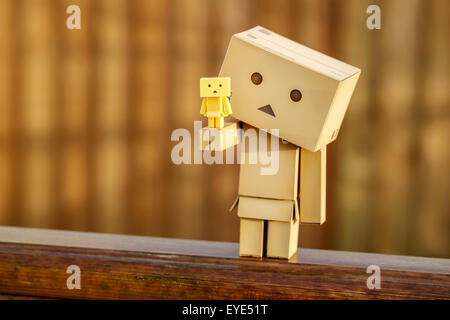 A Manga Japanese toy Danbo Danboard robot character posed for a portrait picture on a warm sunny morning. A large Danbo holding a tiny Danbo Stock Photo