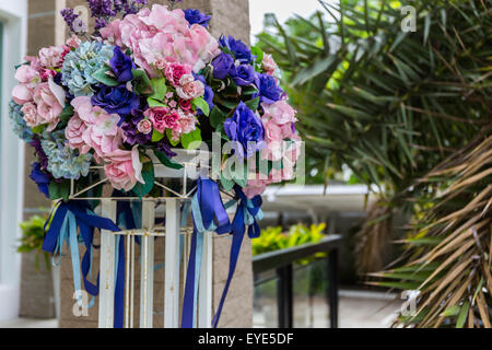 Colorful artificial flower bouquet in front of house. Stock Photo