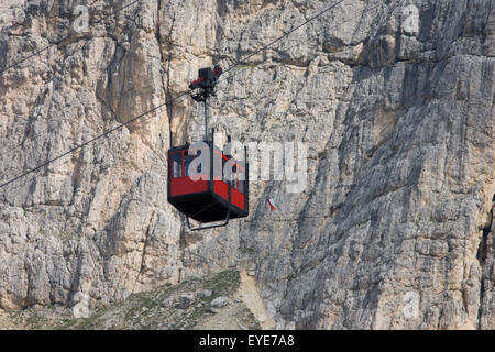 From Passo Falzarega (Pass), a cable car gondola ascends the rock face of Lagazuoi  (3,244 m), a Dolomites mountain in south Tyrol, Italy.  One of two gondolas rises to the Lagazuoi (2,835), which was the object of heavy combat in World War I. Lagazuoi is a mountain in the Dolomites of northern Italy, lying at an altitude of 2,835 metres (9,301 ft), about 18 kilometres (11 mi) southwest by road from Cortina d'Ampezzo in the Veneto Region. It is accessible by cable car and contains the Refugio Lagazuoi, a mountain refuge situated beyond the northwest corner of Cima del Lago. Stock Photo