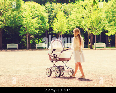 happy mother with stroller in park Stock Photo