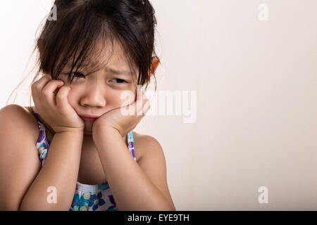 Sad little girl on isolated white background. Stock Photo