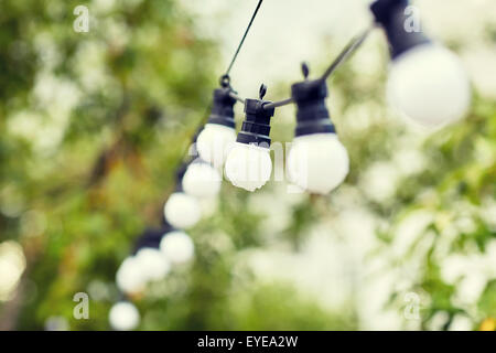 close up of bulb garland hanging in rainy garden Stock Photo