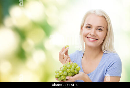 happy woman eating grapes Stock Photo
