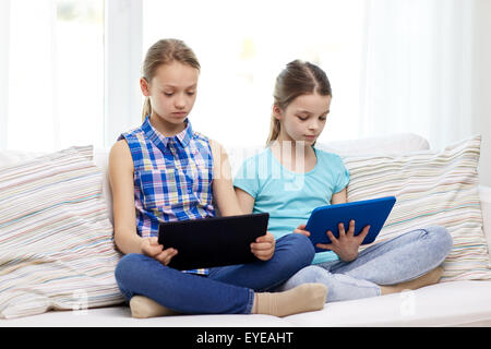 girls with tablet pc sitting on sofa at home Stock Photo