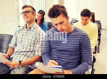 group of smiling students in lecture hall Stock Photo