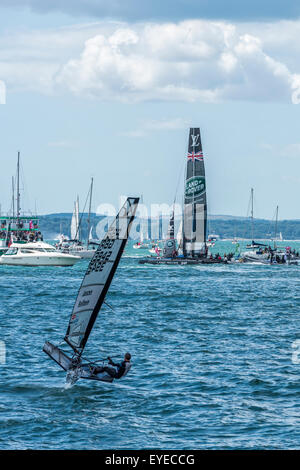 The Team Land Rover BAR America's Cup boat with Jason Belben sailing towards them in a Moth dinghy Stock Photo