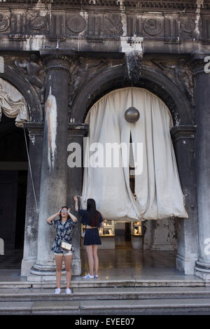 Two Asian girls under the pillars the covered Procuratie Nuovo in Piazza San Marco, Venice, Italy. Stock Photo