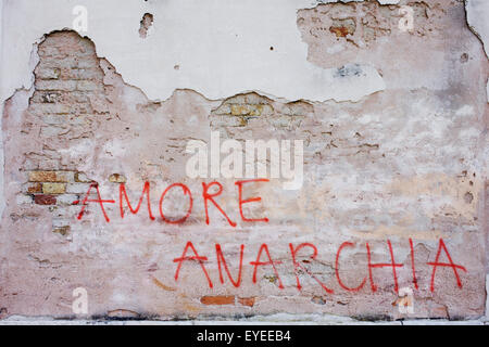 'Love Anarchy' graffiti on a wall on a wall on the Rio de San Margherita canal in Dorsoduro, a district of Venice, Italy. Stock Photo
